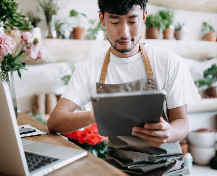 Person working in a flower show on a tablet.