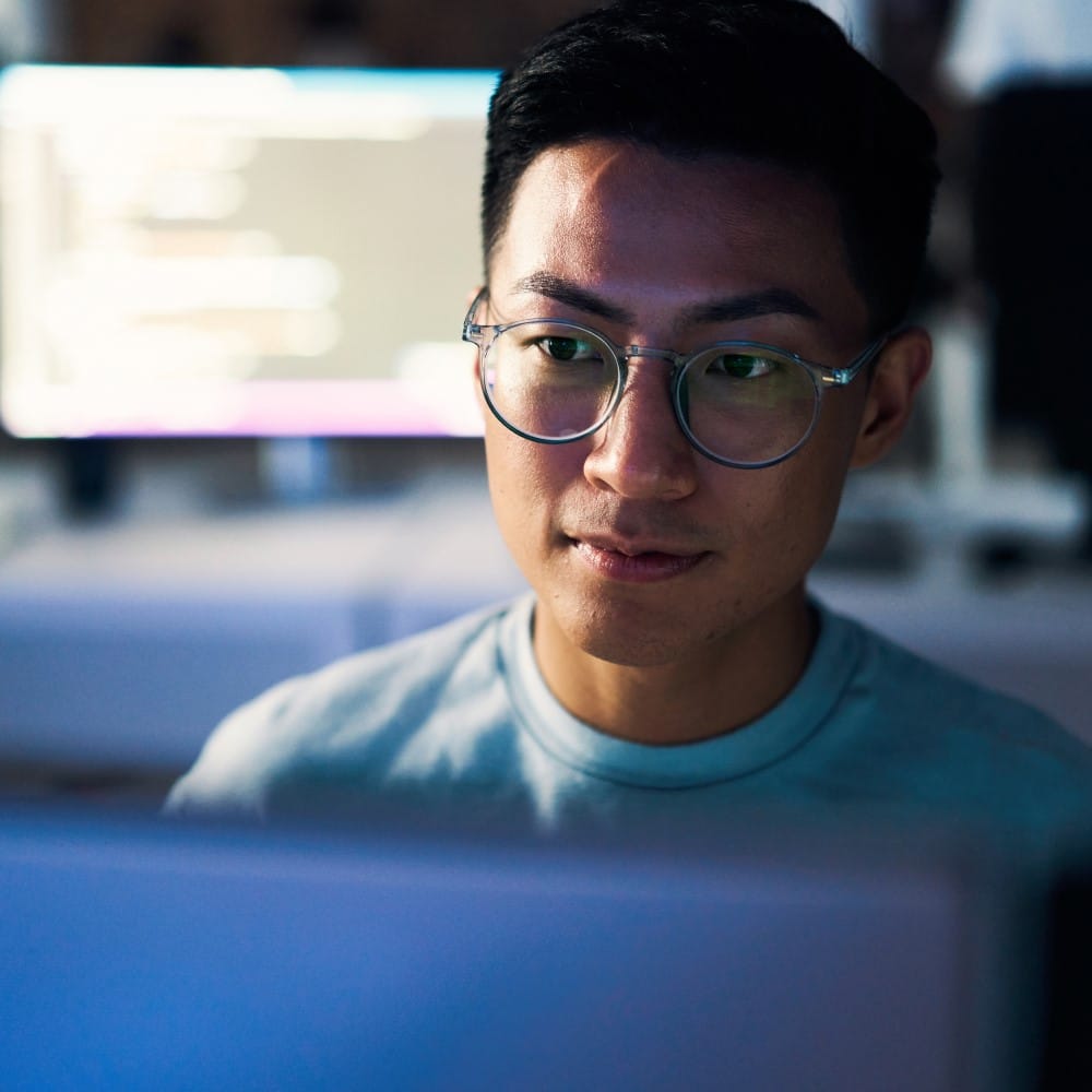 A programmer uses a computer to write code to develop network security and enhance product safety.