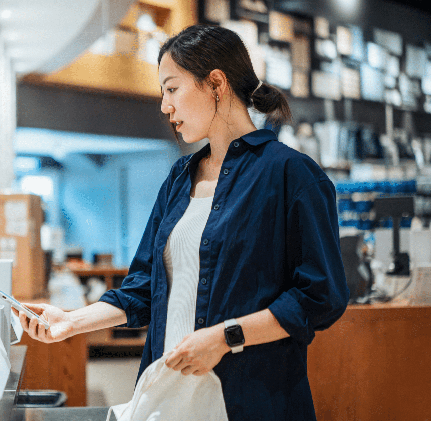 A woman holding a bag and looking at a phone