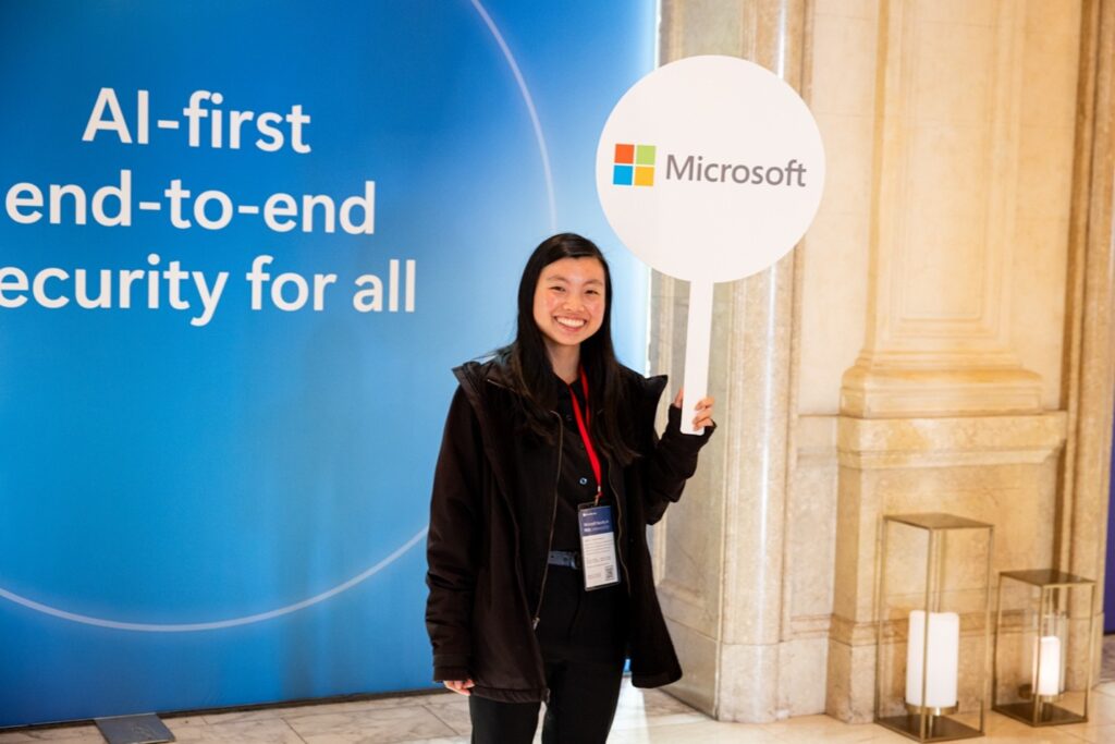 A woman smiling at the Microsoft booth at RSAC 2024.