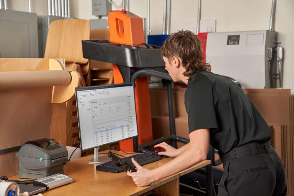 A person standing at a desk with a computer