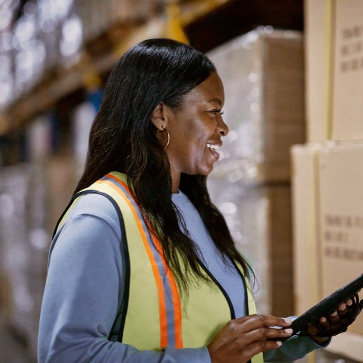 A woman in a warehouse holding a tablet