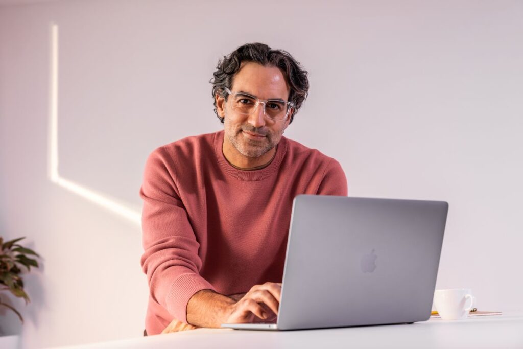 A man sitting at a desk with a laptop